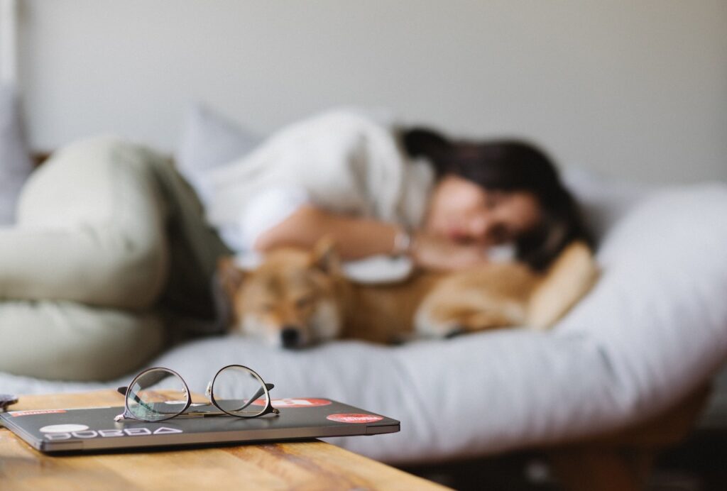 9 tips for restful sleep 1 A woman enjoying restful sleep on a couch with her dog